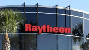Raytheon (RTX) defense company logo hangs on glass building