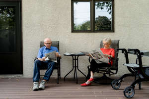 Tom and Acey Hofflander read the daily newspaper on the back porch of their home.