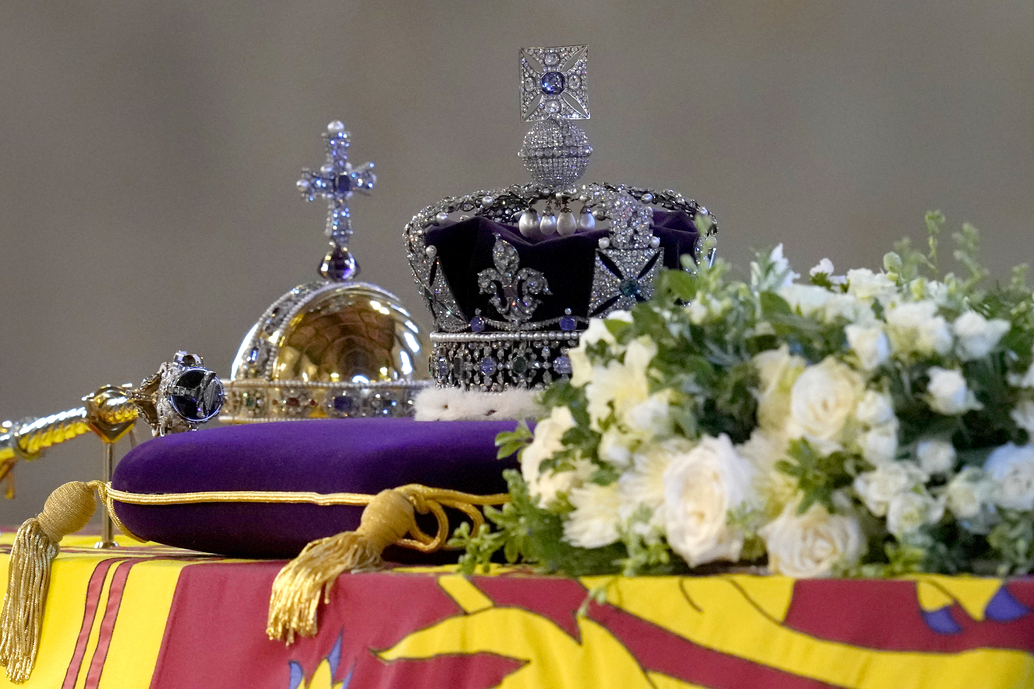 <p>Here's a closer look at what was on top of Her Majesty's coffin... The body of Queen Elizabeth II, her casket draped in the Royal Standard with the Imperial State Crown and the Sovereign's Orb and Sceptre sitting on top, lie in state on a catafalque as members of the public filed past in London's Westminster Hall at the Palace of Westminster on Sept. 16, 2022, ahead of <a href="https://www.wonderwall.com/celebrity/royals/best-photos-from-queen-elizabeth-ii-funeral-king-charles-princes-william-prince-harry-george-charlotte-kate-meghan652347.gallery">her funeral</a> three days later. </p>