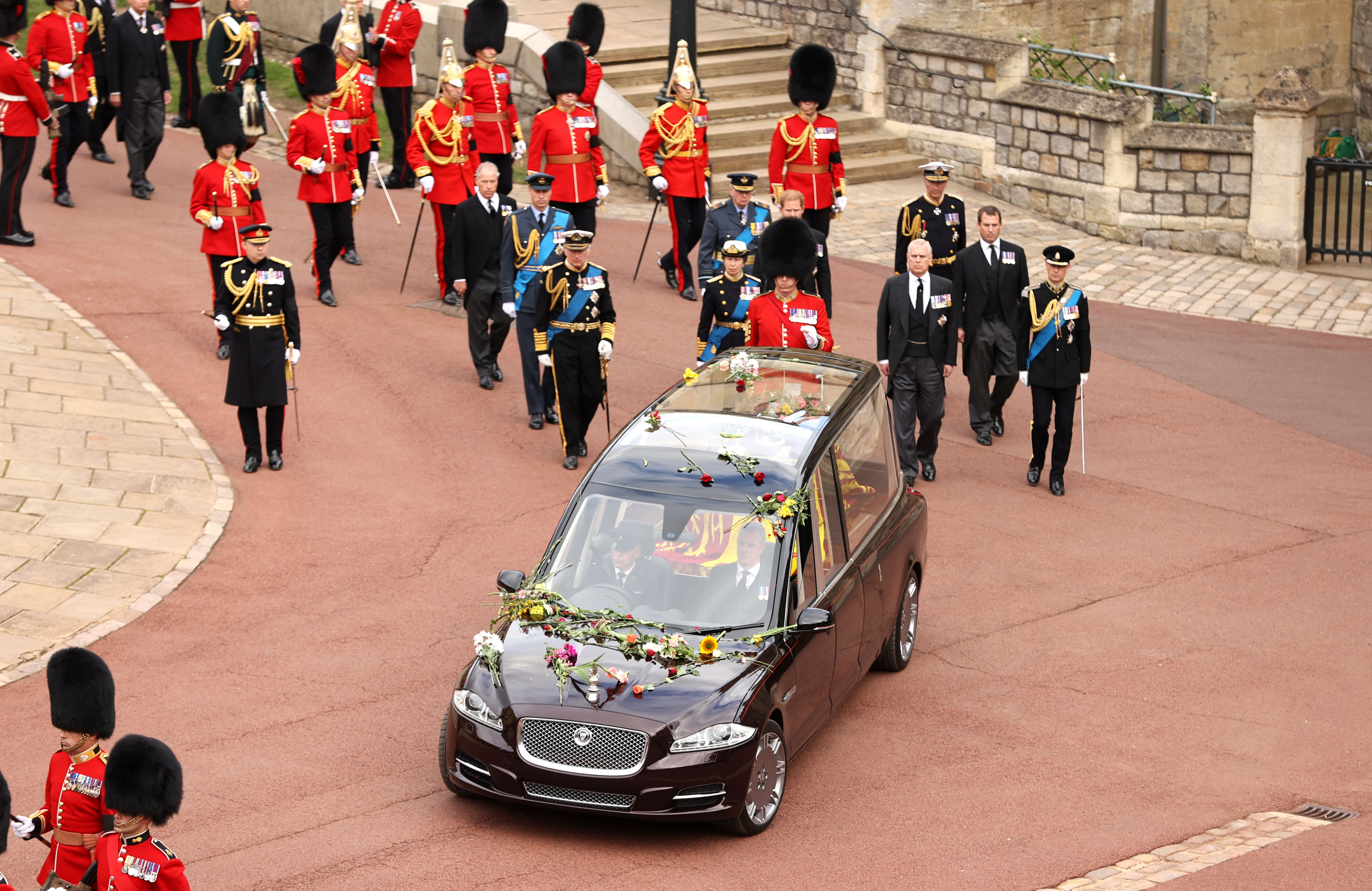 <p>The royal state hearse -- covered in flowers thrown by the grieving public and carrying the coffin of Queen Elizabeth II, which was followed by her children and grandsons -- arrived at Windsor Castle in Windsor, England, for the monarch's committal service at St. George's Chapel on Sept. 19, 2022, following <a href="https://www.wonderwall.com/celebrity/royals/best-photos-from-queen-elizabeth-ii-funeral-king-charles-princes-william-prince-harry-george-charlotte-kate-meghan652347.gallery">her state funeral</a> in London.</p>