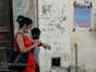 אישה וילד סמוך לשלט הקורא להצביע בעד רפורמת המשפחה, בהוואנה, החודש YAMIL LAGE - AFP