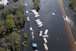 A vehicle drives east on I-70 in floodwaters after Hurricane Ian, Thursday, Sept. 29, 2022, near Arcadia, Fla.