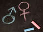 Male and female symbols drawn using chalk on a chalkboard