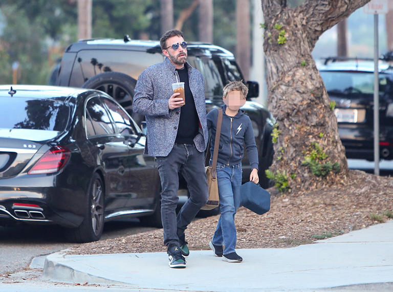 Ben Affleck held hands with his youngest child with Jennifer Garner, son Samuel, 10, as they walked home from school in Santa Monica. The photo was taken on Oct. 21, 2022. Ben carried a coffee, while Sam juggled a backpack and a lunchbox. 