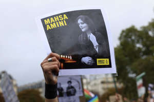 A protester shows a portrait of Mahsa Amini during a demonstration to support Iranian protesters standing up to their leadership over the death of a young woman in police custody, Sunday, Oct. 2, 2022 in Paris. AP Photo/Aurelien Morissard