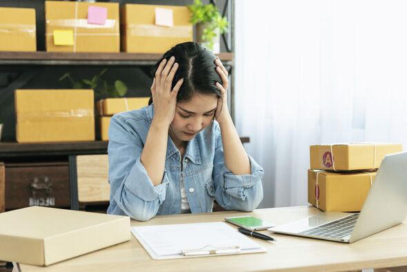 Desperate Asian woman stress headache depressed from startup small business at home office. Failure business woman work at home office. Online seller 
