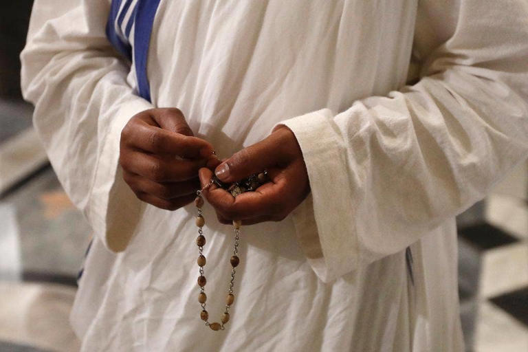 A nun of Mother Teresa's Missionaries of Charity holds a rosary during a vigil of prayer in preparation for the canonization of Mother Teresa in the St. John in Latheran Basilica at the Vatican in 2016. The Associated Press/Gregorio Borgia