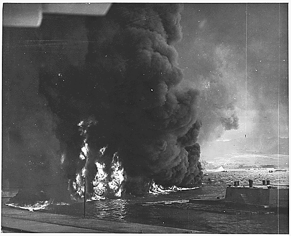 <p>Smoke billowing from oil burning on top of the water around Ford Island. Oil continuously seeped into the ocean from the damaged battleships and was set ablaze by the burning vessels and aerial bombings.</p>