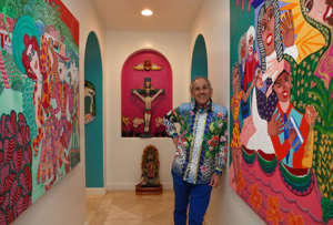 Actor and artist Pepe Serna stands by his painting, "Family in Crisis," inside his home in Rancho Mirage, Calif., on Nov. 28, 2022. He is the subject of the film "Life is Art" which will be shown at the Official Latino Film and Arts Festival in Palm Springs.