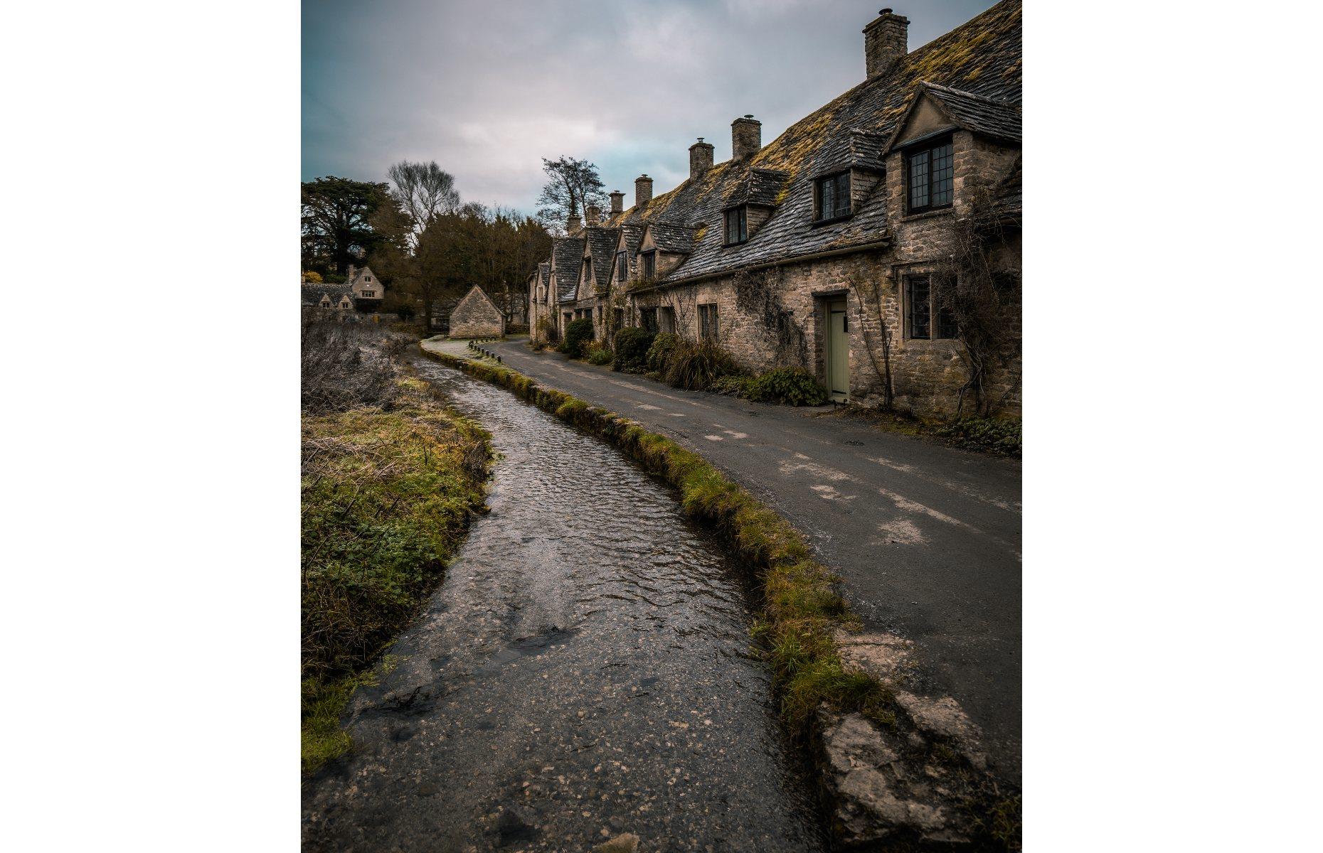 <p>The charming Cotswolds village of Bibury takes on an altogether spookier look in this atmospheric shot, which was taken by Vitalij Bobrovic. Judges praised how the photograph showed off the unique character and identity of the settlement, which was described by textile designer William Morris (1834-96) as "the most beautiful village in England".</p>  <p><a href="https://www.loveexploring.com/gallerylist/69165/the-uks-prettiest-small-towns-and-villages-2021"><strong>Discover more of the UK's most charming villages</strong></a></p>