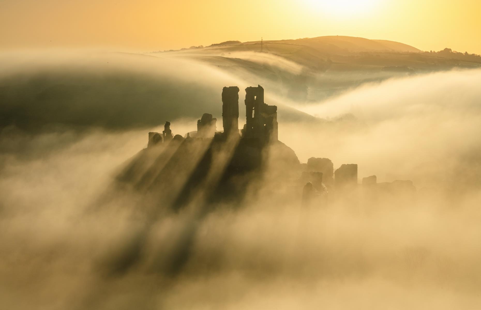 <p>Photographer Edyta Rice said it took "many attempts" to get the perfect image of Corfe Castle in misty conditions, adding that "rising sun, a golden glow and shadows falling behind the towers" eventually combined to give her the dream shot. The royal castle, which was established by William the Conqueror in the 11th century and was partially destroyed during the English Civil War (1642–1651), is one of <a href="https://www.loveexploring.com/news/114240/best-places-to-visit-in-dorset-lyme-regis-swanage-sherborne-2021">Dorset</a>'s most famous historic landmarks. </p>