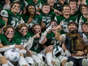 Grand Rapids West Catholic players hold a trophy after the 59-14 win in the Division 6 state final at Ford Field on Friday, Nov. 25, 2022.