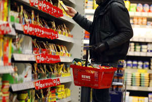 Ein Kunde steht in Köln in einem Rewe-Supermarkt an einem Regal. Die Aufnahme dient hierbei als Symbolfoto.