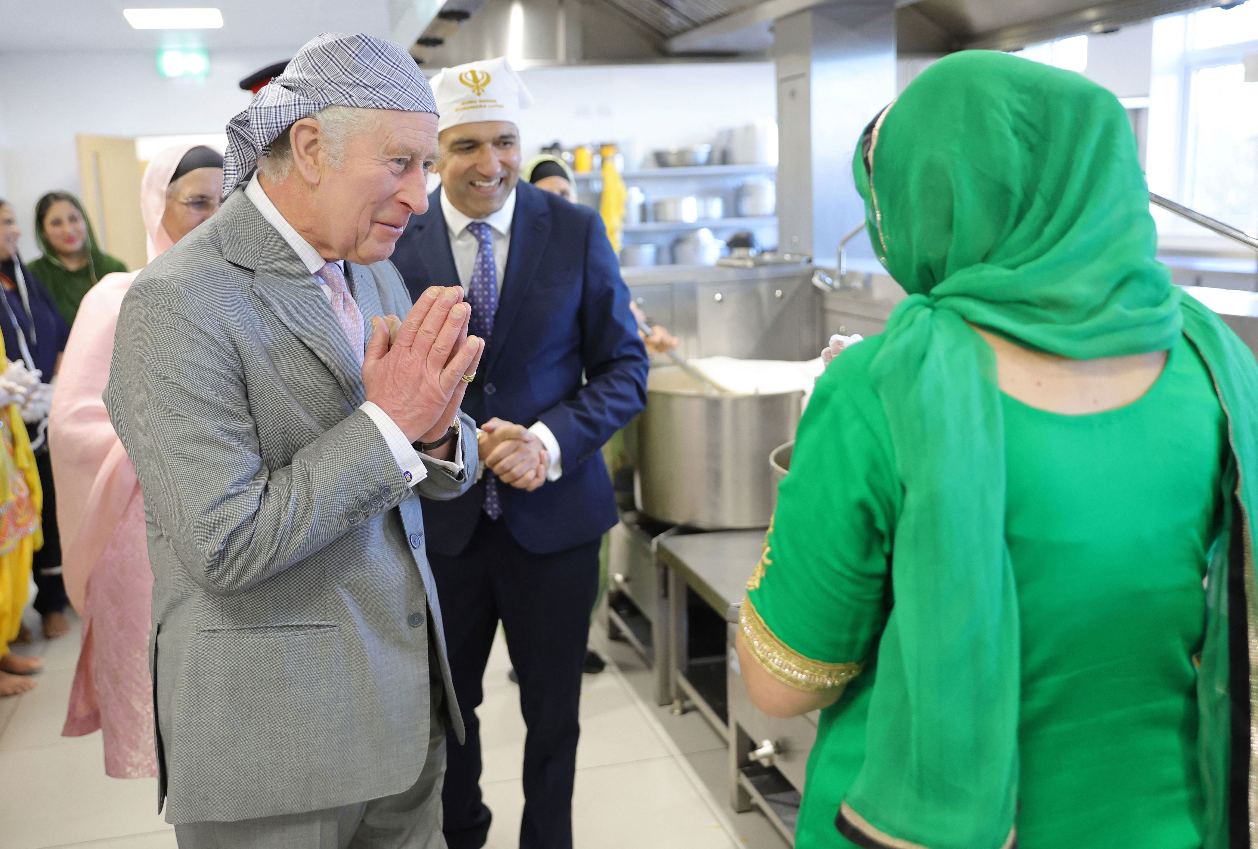 <p>King Charles III made a traditional namaste greeting gesture as he spoke to volunteers at the Luton Sikh Soup Kitchen Stand during his visit to the newly built Guru Nanak Gurdwara -- which provides Sikh religious teaching and practice for members of the community as well as voluntary social services for the elderly, youth and other groups -- in Luton, England, on Dec. 6, 2022.</p>