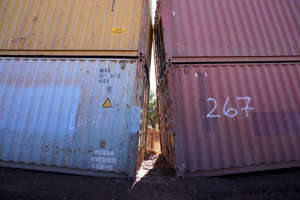 An awkward gap is shown between shipping containers at the bottom of a wash along the border where shipping containers create a wall between the United States and Mexico in San Rafael Valley, Ariz., Thursday, Dec. 8, 2022. Work crews are steadily erecting hundreds of double-stacked shipping containers along the rugged east end of Arizona’s boundary with Mexico as Republican Gov. Doug Ducey makes a bold show of border enforcement even as he prepares to step aside next month for Democratic Governor-elect Katie Hobbs.