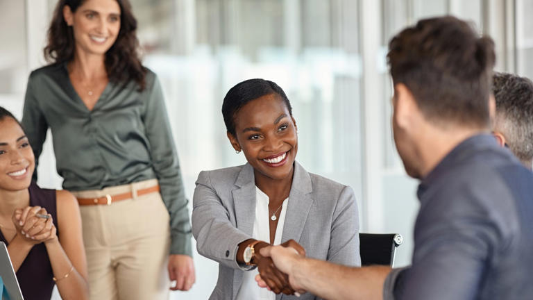 Mature black businesswoman shaking hands with new business partner