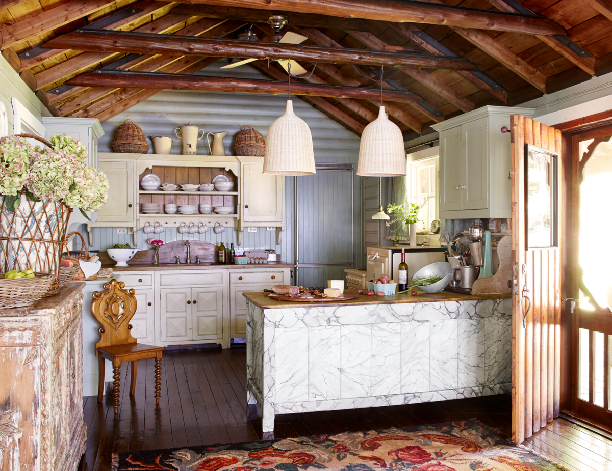 <p>In <a href="http://www.colettevandenthillart.com/">Colette van den Thillart's</a> Canadian cabin, English country cottage-style cabinetry <a href="https://www.smallbone.co.uk/">Smallbone of Devizes</a> reinforces the rustic look. A trip to Denmark inspired the kitchen island's marbleized design. The paneled and log walls are painted in a custom Benjamin Moore paint.</p>