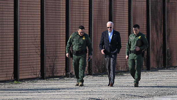 US President Joe Biden speaks with a member of the US Border Patrol as they walk along the US-Mexico border fence in El Paso, Texas, on January 8, 2023.