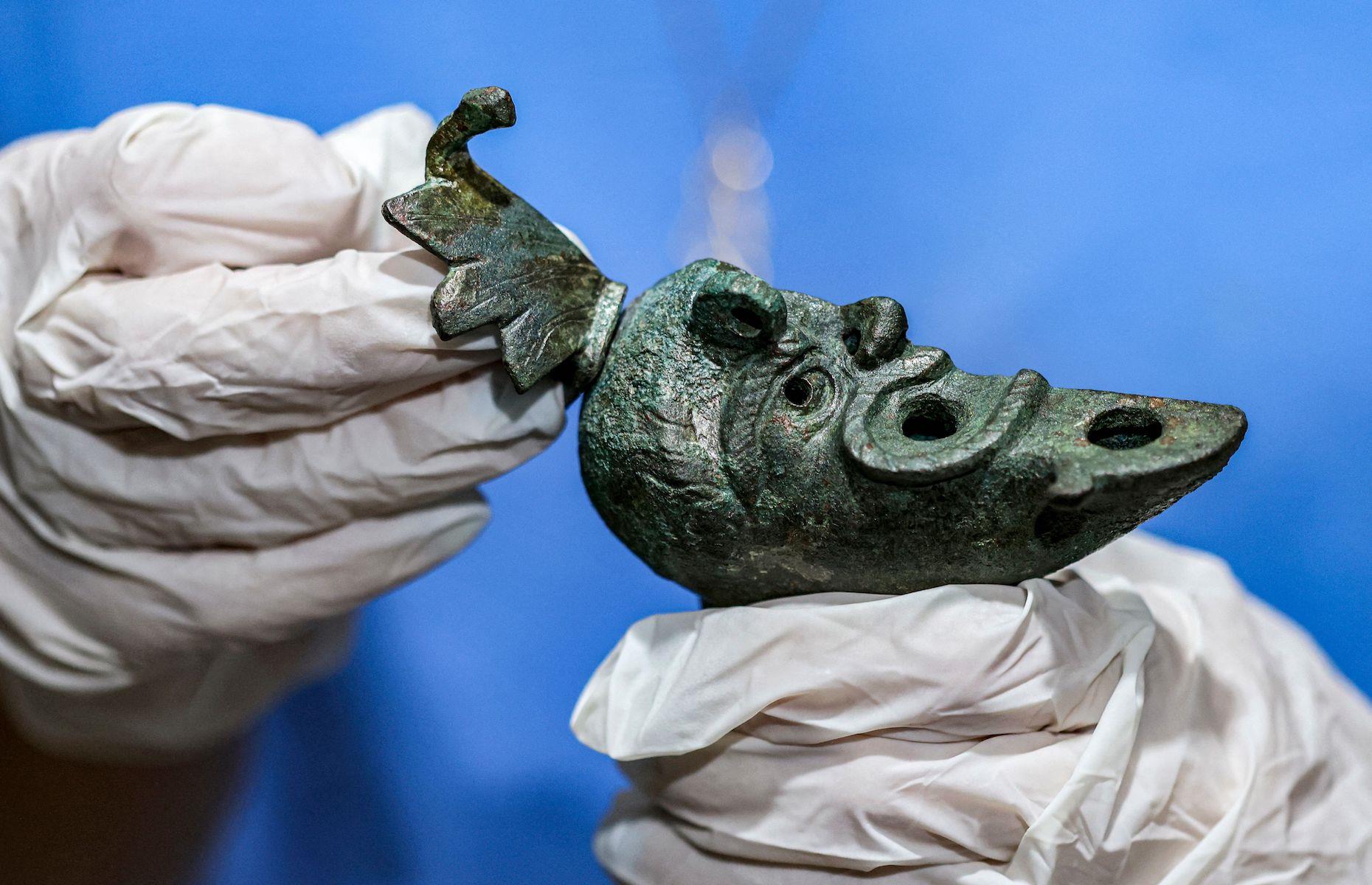 <p>In May 2021, <a href="https://www.timesofisrael.com/rare-2000-year-old-oil-lamp-shaped-like-grotesque-face-found-in-city-of-david/">a rare and bizarre-looking bronze oil lamp was discovered</a> by Israeli archaeologists in the foundation of a building erected in Jerusalem’s City of David almost 2,000 years ago. The Israel Antiquities Authority said it believed the lamp, which is shaped like half a head of a bearded man, was deposited as an offering to bring good fortune to the building’s residents. It’s estimated to be from the late 1st century or early 2nd century. The lamp’s unusually well-preserved wick was also discovered at the excavation site. </p>