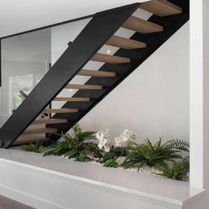 Cheer up your basement with an indoor atrium at the base of the stairs. This idea from @rzinteriors_ is simple but impactful, creating an unexpected feature in a space that's usually wasted. If your basement receives natural light, you can install low-maintenance live plants like zz plant or pothos. If your thumb is more black than green, display several faux plants for the same effect.