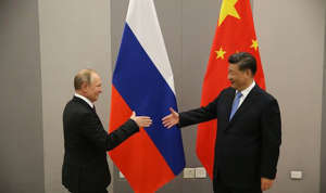 Vladimir Putin and Xi Jinping shake hands at a Russia-China summit