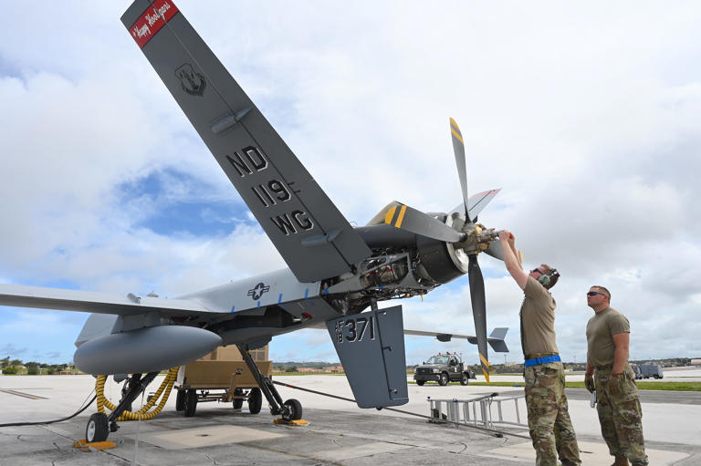 US Air Force airmen adjust propeller weight during pre-flight checks on an MQ-9 at Andersen Air Force Base in Guam in May 2022. US Air Force/Airman 1st class Christa Anderson