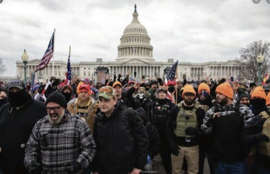 Joe Biggs, bottom left, in gray and black checked jacket, marches at the Jan. 6 riot at the U.S. Capitol, in this photo shared in a Department of Justice affidavit supporting Biggs' arrest.