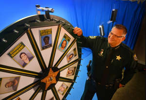 2017: Sheriff Wayne Ivey demonstrates the 'Wheel of Fugitive' board