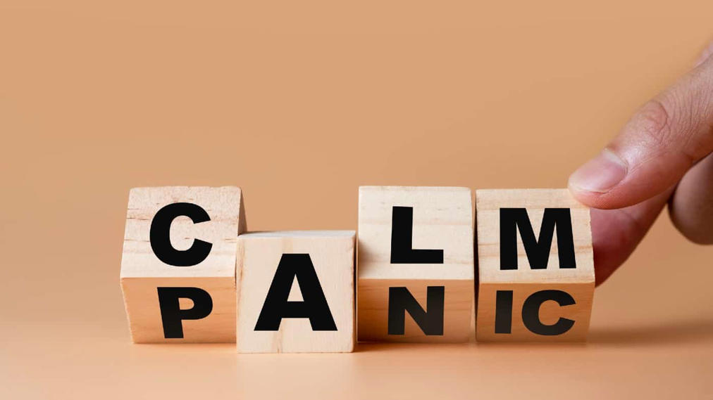 Hand flipping wooden cubes for change wording" Panic" to " Calm".