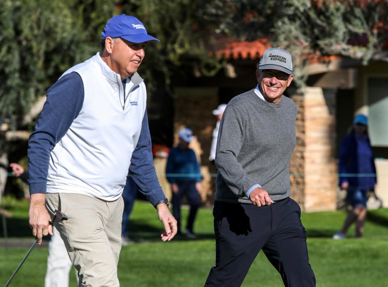 PGA Tour Commissioner Jay Monahan smiles at American Express CEO Stephen Squeri as they approach the second green during round one of The American Express golf tournament at La Quinta Country Club in La Quinta, Calif., Thursday, Jan. 19, 2023.