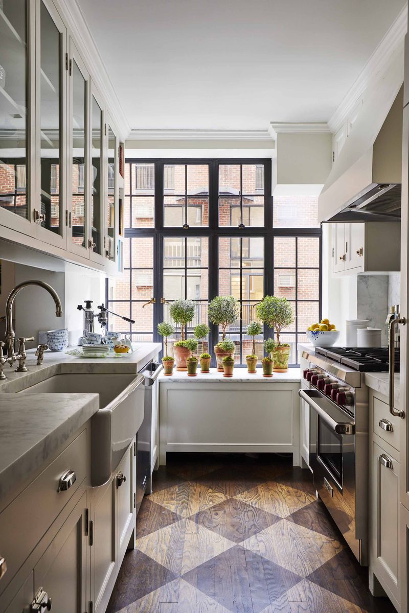 <p>In <a href="https://www.veranda.com/decorating-ideas/house-tours/a36082852/cece-barfield-gramercy-park-house-tour/">designer Cece Barfield Thompson's New York City apartment</a>, a large-scale checkerboard pattern (<a href="https://www.floepainting.com/">Floe Painting</a>) helps make the tiny kitchen appear more spacious. The steel casement windows are original. </p>