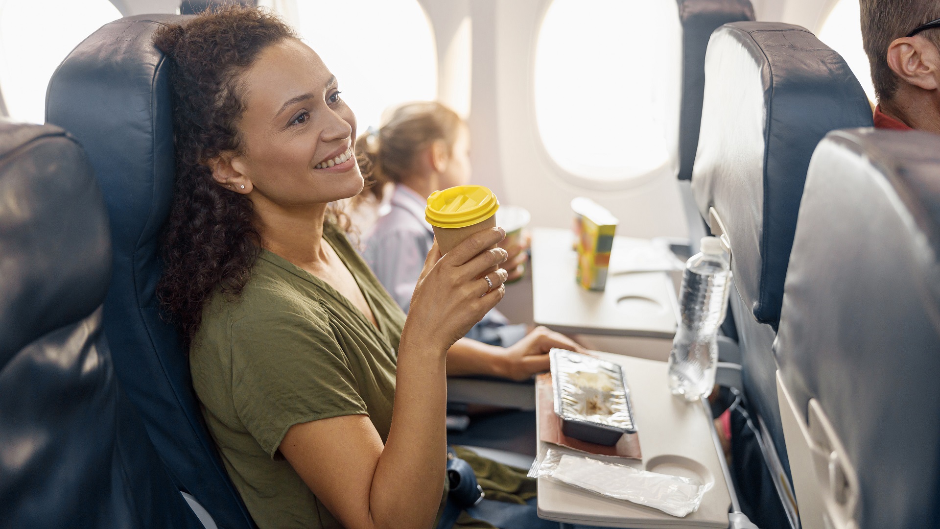 happy woman sits with child airplane flight_iStock-1335408660