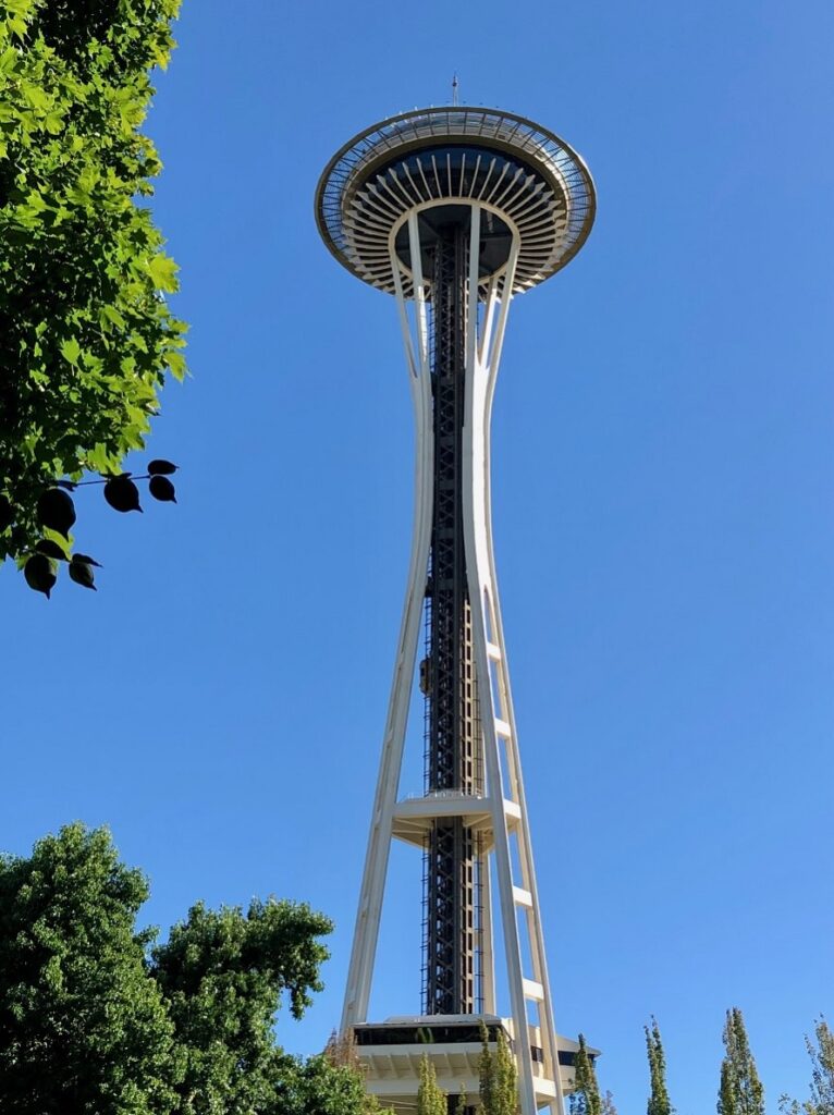 <p><em>By Lisa of Waves and Cobblestones</em></p> <p>The Space Needle is located in Seattle, Washington, in the United States.  It's not only one of the most <a href="https://wavesandcobblestones.com/best-things-to-do-in-seattle-in-a-day/" rel="noreferrer noopener">famous attractions in Seattle</a>, it's one of the most iconic landmarks in the world!</p> <p>The Space Needle is a 605' high observation tower and was built for the 1962 World's Fair.  The Space Needle's iconic architecture is based on the World's Fair theme. ‘Age of Space'.  The chief architect wanted the top to look like a flying saucer, which enhances the futuristic concept.</p> <p>Guests take an elevator up to the top of the Space Needle.  The two passenger elevators are high-speed elevators, able to travel at speeds of up to 10mph.  There is one yearly opportunity to climb the 832 stairs of the Space Needle, during the annual charity event, the Base2Space stair climb.</p> <p>Intrepid visitors can take in the stunning panoramic views of <a href="https://wanderwithalex.com/things-to-do-seattle-washington/">downtown Seattle</a>, the Puget Sound, and the Olympic mountains from the Needle’s open-air observation deck, which is 520 feet above ground.</p> <p>There is also an indoor observation level with a rotating glass floor (the Loupe), which is 500 feet above the ground.  It takes 30 minutes for a full revolution, so why not enjoy a drink or a snack in the Loupe Lounge while you enjoy the full 360-degree views of Seattle?</p>