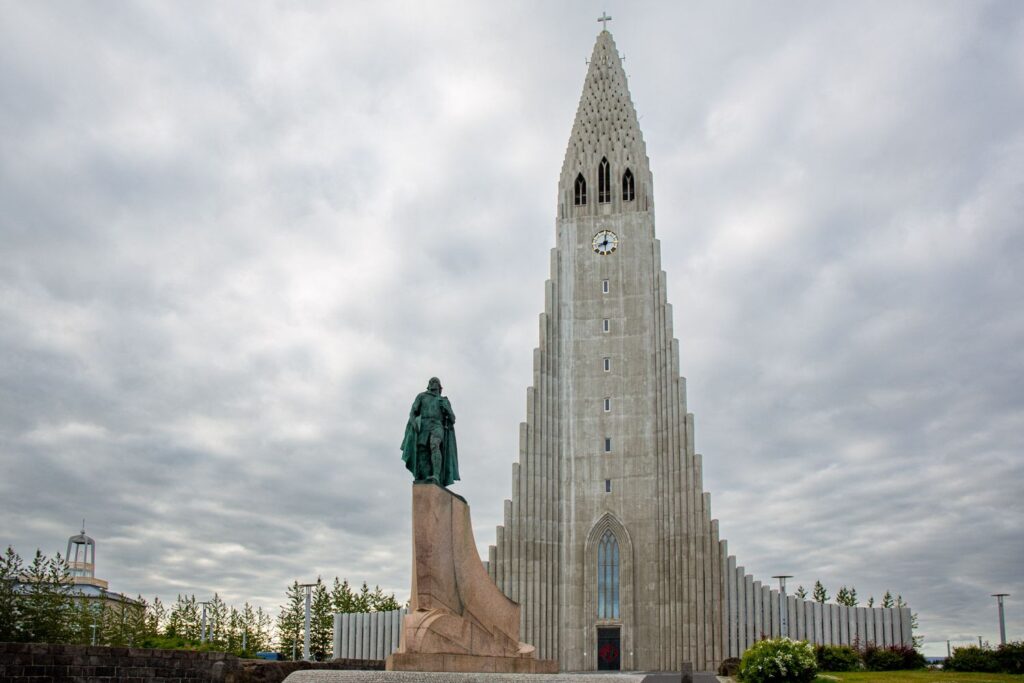 <p><em>By Suzanne of Meandering Wild</em></p> <p>This stunning church is dominant on the <a href="https://meanderingwild.com/views-over-reykjavik/" rel="noreferrer noopener">Reykjavík skyline</a> forming a recognisable silhouette. It stands 74 metres tall on Skólavörðuhæð hill and can be seen from almost everywhere in the city.  It is located at the top of Skólavörðustígur and views from the bottom of the hill over the rainbow painted road is one of the best-known views in Reykjavík.</p> <p>Inspired by a blend of Scandinavian modernism and the Icelandic landscape the architect took inspiration from the basalt columns at Svartifoss waterfall on the south coast of Iceland.  The basalt column shapes can be seen in the external pillars of the church and rise to a peak at the centre of the spire.</p> <p>The interior is calm and simple, true to the Lutheran style apart from the spectacular pipe organ with its 5275 pipes. It is a working church and you will often find services and recitals which fill the church with beautiful sound.</p> <p>A lift gives access to the open spire where views across the city and Faxaflói towards Snæfellsjökull volcano are stunning. Each  of the four sides of the spire has a different view giving a 360 view across the city and beyond.</p>