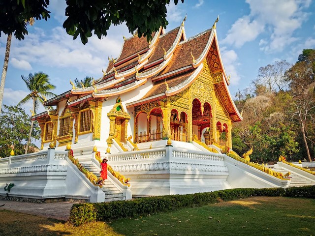 <p><em>By Roshni from The Wanderlust Within</em></p> <p>One of the best <a href="https://www.thewanderlustwithin.com/things-to-do-in-luang-prabang-laos/" rel="noreferrer noopener">things to do in Luang Prabang</a> is visit the beautiful Wat Xieng Thong, located in the same complex as the Royal Palace Museum in Laos.</p> <p>It is one of the largest temples in the country, and is also known as the ‘Golden Tree Monastery’ or the “Monastery of the Golden City”. Built in the 16th century by King Setthathirath, to commemorate the legendary King Chanthaphanith, it acts as a gateway to Luang Prabang with its strategic position close to where the Mekong River joins the Nam Khan River.</p> <p>The site is famous as the location for the coronation of Lao kings, and the architecture references Luang Prabang, with elaborate mosaic patterns, wall carvings, rare Buddhist deities, a 12 metre funeral carriage and a pointed Vihan.</p> <p>Nowadays tourists are able to visit Wat Xieng Thong, however they must be dressed appropriately (shoulders and knees covered) and act respectfully. The temple is only open a few hours a day so check before you visit but if you can then 6pm is a great time as you can witness the monks and novices taking part in their daily prayers and chants.</p>