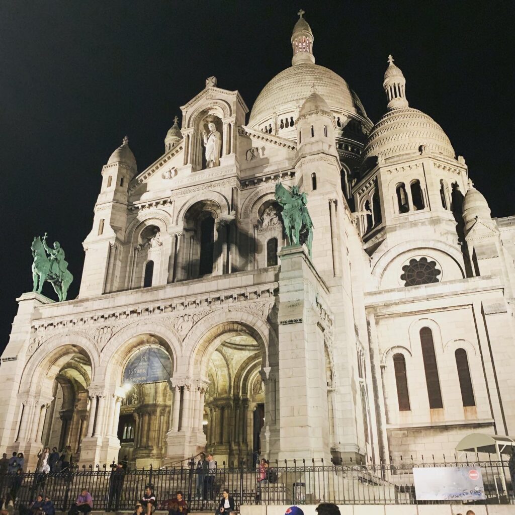 <p>The Basilica of Sacré-Coeur de Montmartre is a stunning Roman Catholic church that is known for its beautiful architecture and panoramic views of the city. This Paris landmark was built in the late 19th century and dedicated to the Sacred Heart of Jesus as a symbol of faith and hope for the people of France. </p> <p>The church’s unique design, which includes a striking white dome, intricate carvings, and beautiful stained-glass windows, draws visitors from around the world. You can climb the dome to enjoy breathtaking views of the city, or explore the basilica’s interior and admire its magnificent mosaics and paintings. </p>