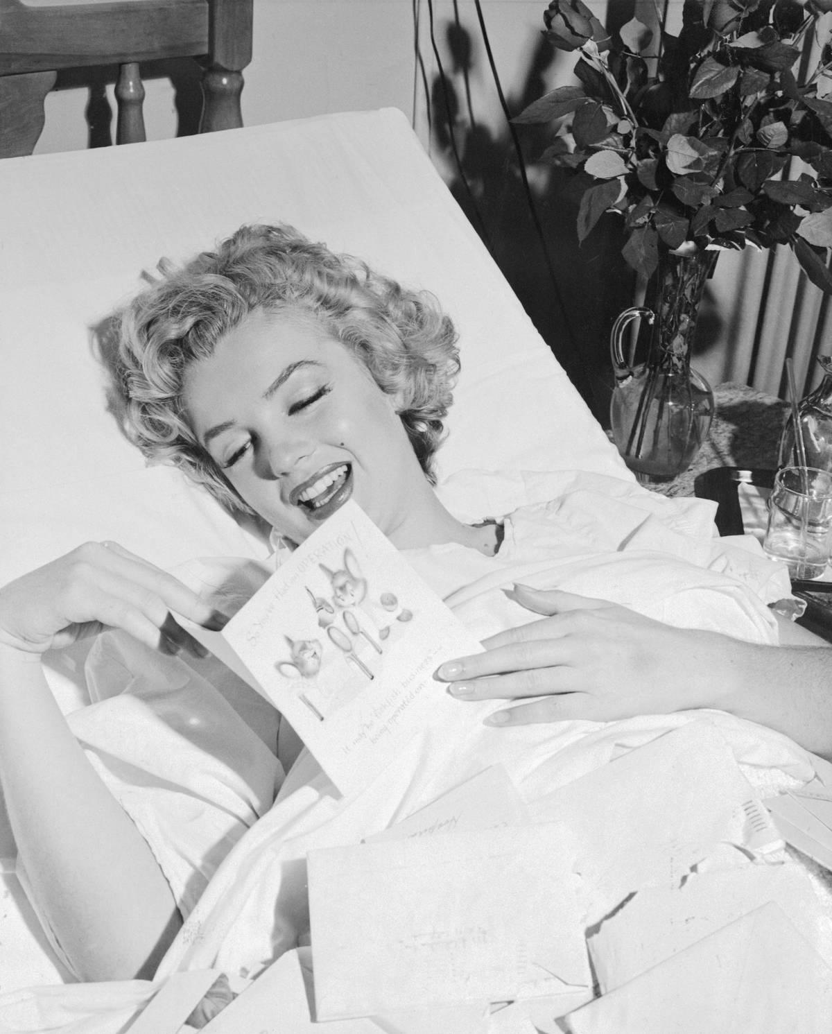 <p>From 1954 to 1955, actress and model Marilyn Monroe was connected to Yankee superstar Joe DiMaggio. They had a brief but epic romance which is seen here, even though DiMaggio isn't in the photo.</p> <p>While lying in bed, Monroe is seen smiling as she reads a get-well card from the baseball player.</p>