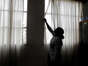 A Foreign domestic worker closes the curtains of her room (Photo by JOSEPH EID / AFP)