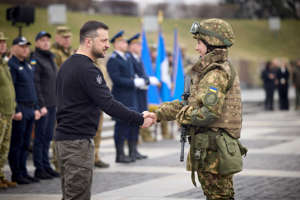 This handout picture taken and released by Ukrainian Presidential press-service on March 24, 2023, shows the President Volodymyr Zelensky (L) shaking hands with a serviceman during a ceremony of the 9th anniversary of the National Guard of Ukraine and the graduation of the officers of the National Academy of Ukraine, in Kyiv.