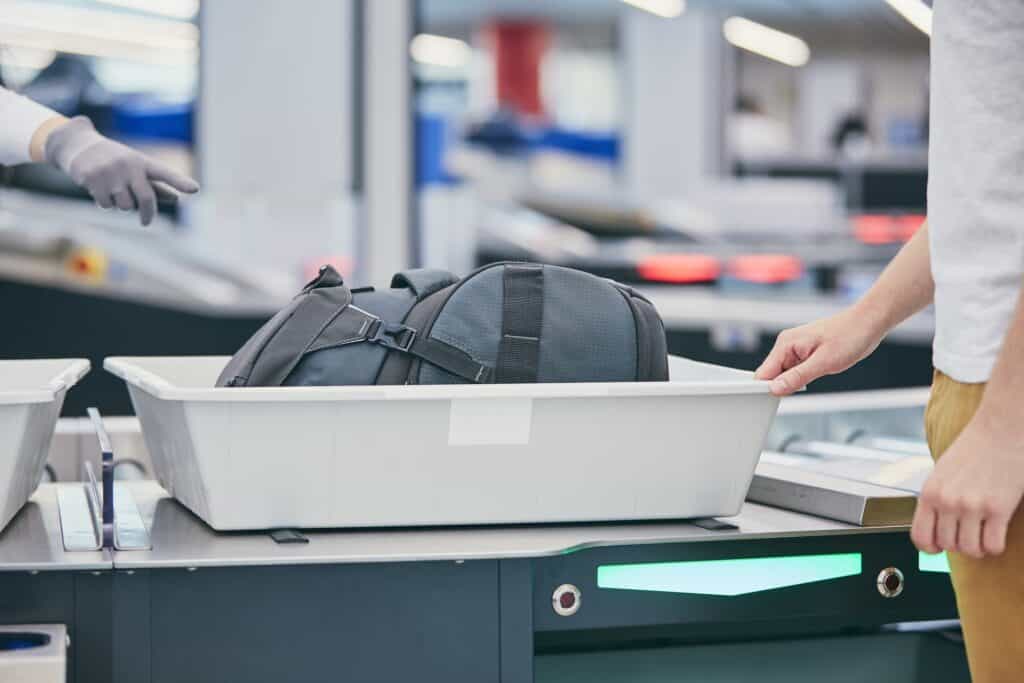 <p>The second checkpoint ensures that restricted items are not brought onto the plane. Once you reach this point, you’ll need to do a few things. </p> <ul>   <li>Remove electronics from your carry-on and personal item and place them in a gray bin. The gray bin will then go on rollers that will carry your items to the baggage scanner. Some baggage scanners are more advanced and don’t require removing your electronics, but every airport is different. </li>   <li>Remove your coat, belt, and shoes and place them in a gray bin and on the rollers. You’ll also be required to empty your pockets. </li>   <li>Place your personal item in a gray bin</li>   <li>Place your carry-on luggage on the rollers</li>  </ul> <p>If you follow my advice and pack according to <a href="https://www.tsa.gov/travel/security-screening" rel="noreferrer noopener nofollow">TSA guidelines</a>, this should be a breeze.</p>