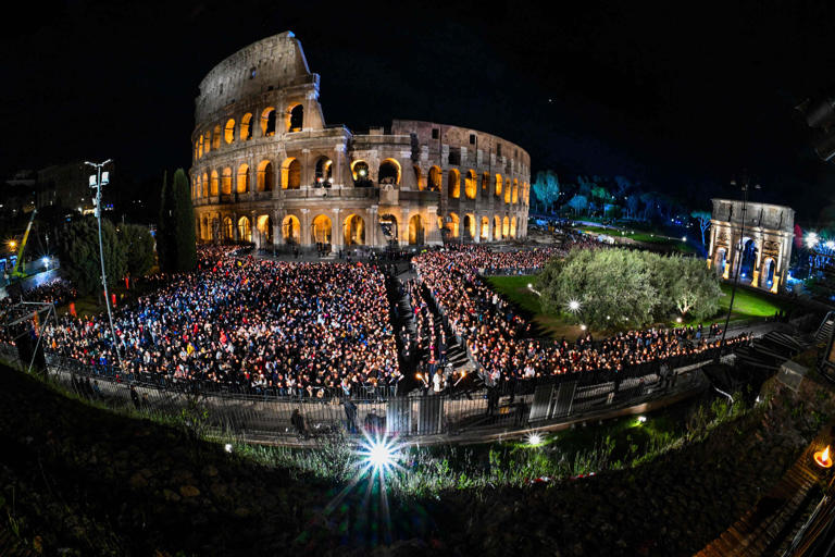 A general view shows people gather by the Colosseum monument in Rome during the Way of the Cross (Via Crucis) prayer service in Rome on April 7, 2023 as part of celebrations of the Holy Week.