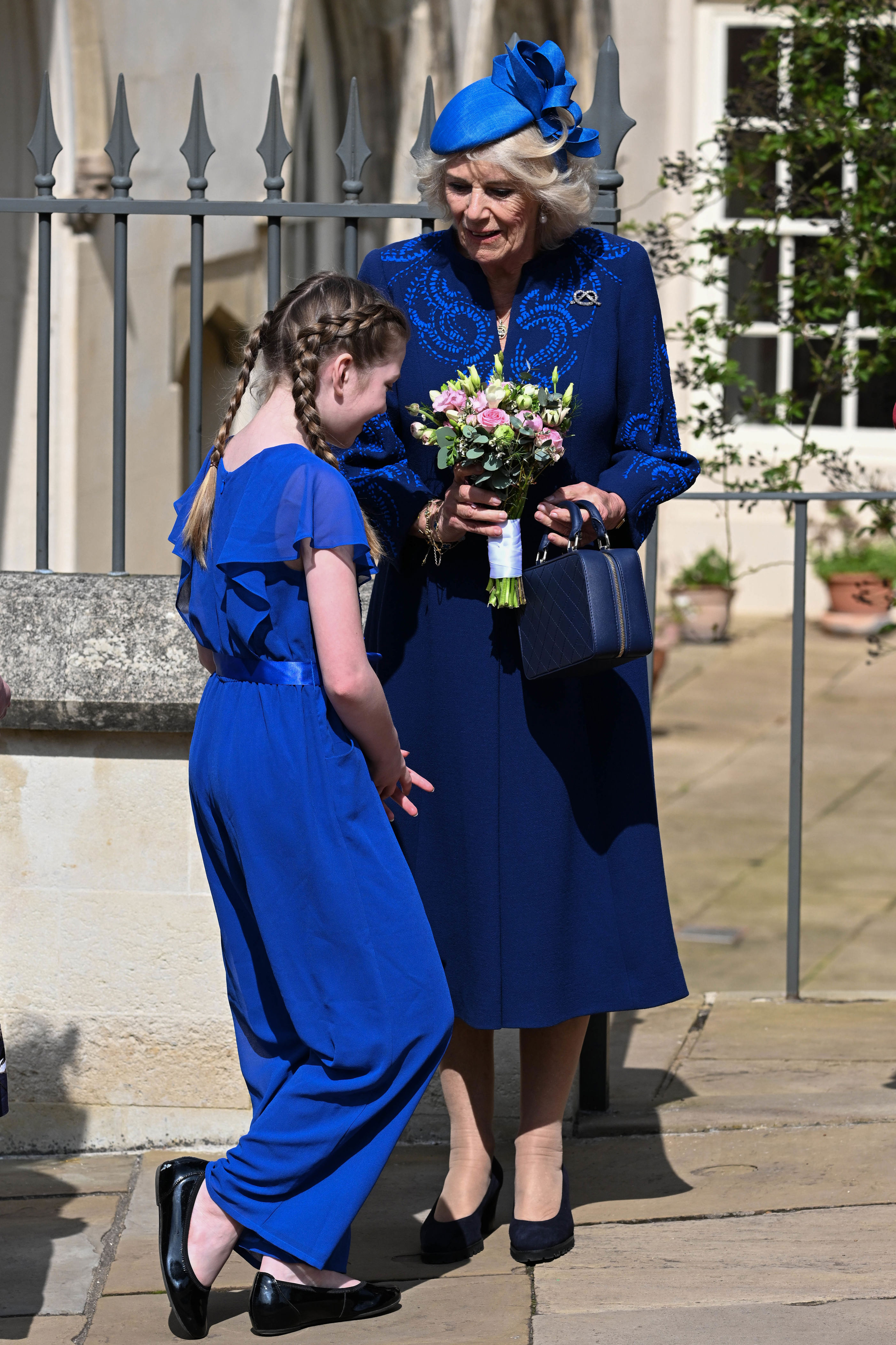 <p>Queen Consort Camilla accepted a bouquet of flowers from a young girl following the Easter Mattins Service at St. George's Chapel at Windsor Castle in England on April 9, 2023.</p>