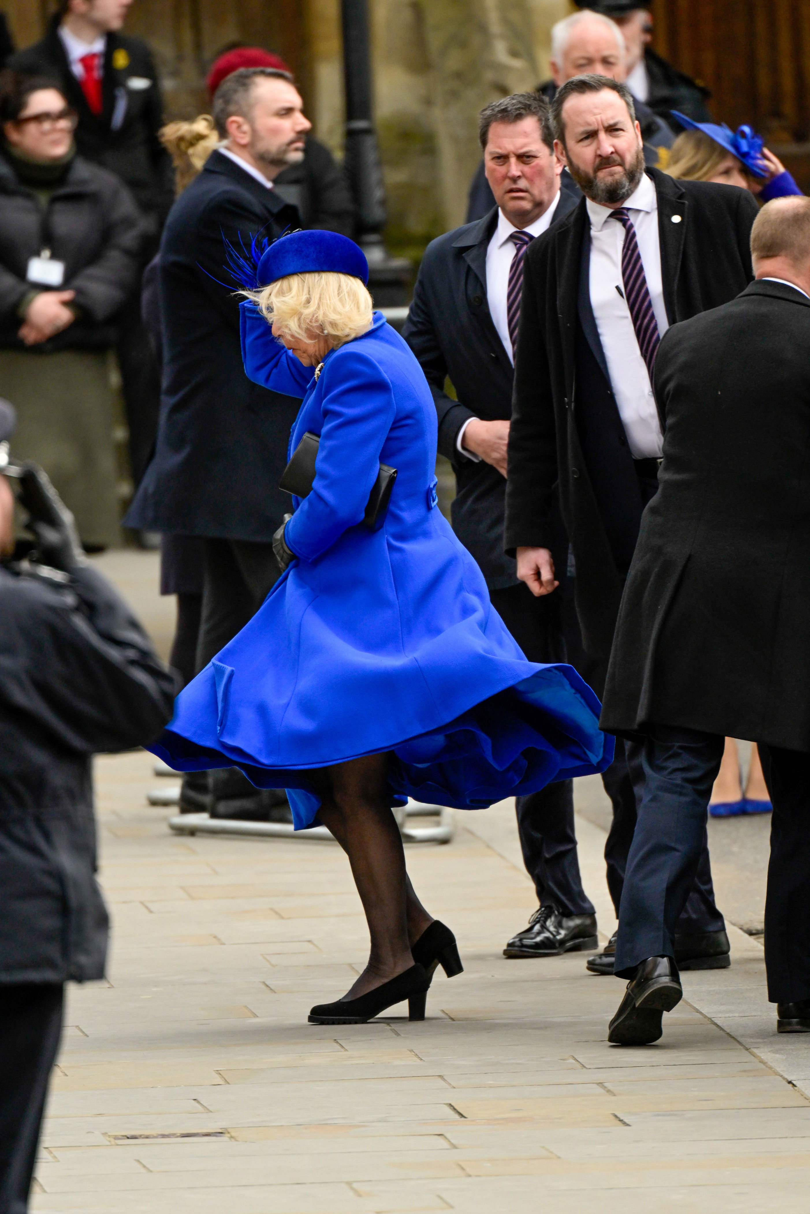 <p>Queen Consort Camilla battled a gust of wind as she arrived at the annual Commonwealth Day Service at Westminster Abbey in London on March 13, 2022 -- the first of husband King Charles III's reign.</p>