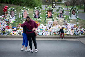 People gather at a memorial outside of Covenant School in Nashville, Tenn., Thursday, March 30, 2023. A shooting at the school on Monday left three adults and three children dead.