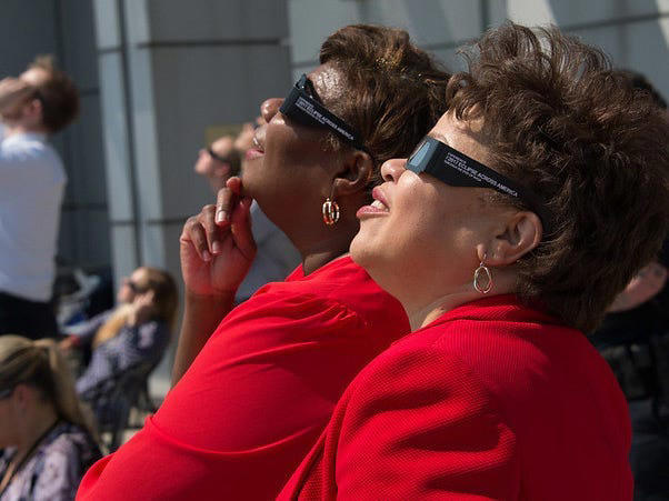 NASA employees use protective glasses to view a partial solar eclipse. NASA/Connie Moore