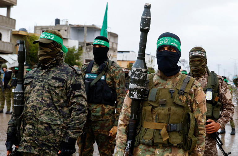 Hamas militants standing guard during a recent handover of hostages in Rafah.