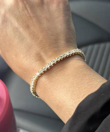 A hand modeling an elegant, sparkling gold and diamond bracelet, suitable for shopping and fashion features