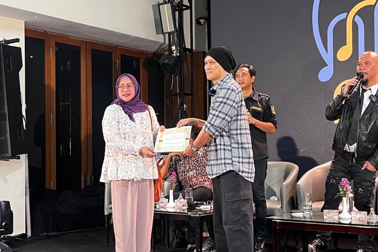 Dewa 19 diwakili Andra memberikan fee royalti kepada istri Erwin Prasetya dalam diskusi AKSI di daerah Senayan, Jakarta Pusat, Jumat (28/2/2025).