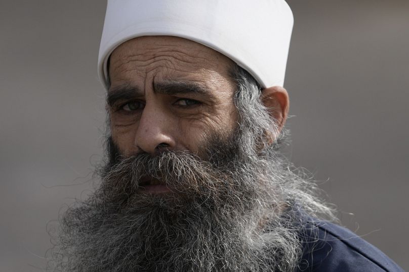 رجل يمشي في قرية مجدل شمس الدرزية، الواقعة بالقرب من ”خط ألفا“ الذي يفصل مرتفعات الجولان التي تسيطر عليها إسرائيل عن سوريا، الخميس، 12 ديسمبر/كانون الأول 2024 Matias Delacroix/AP