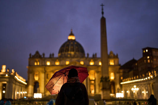 A woman prays for the Pope at the Vatican’s St Peter’s Square (AP)